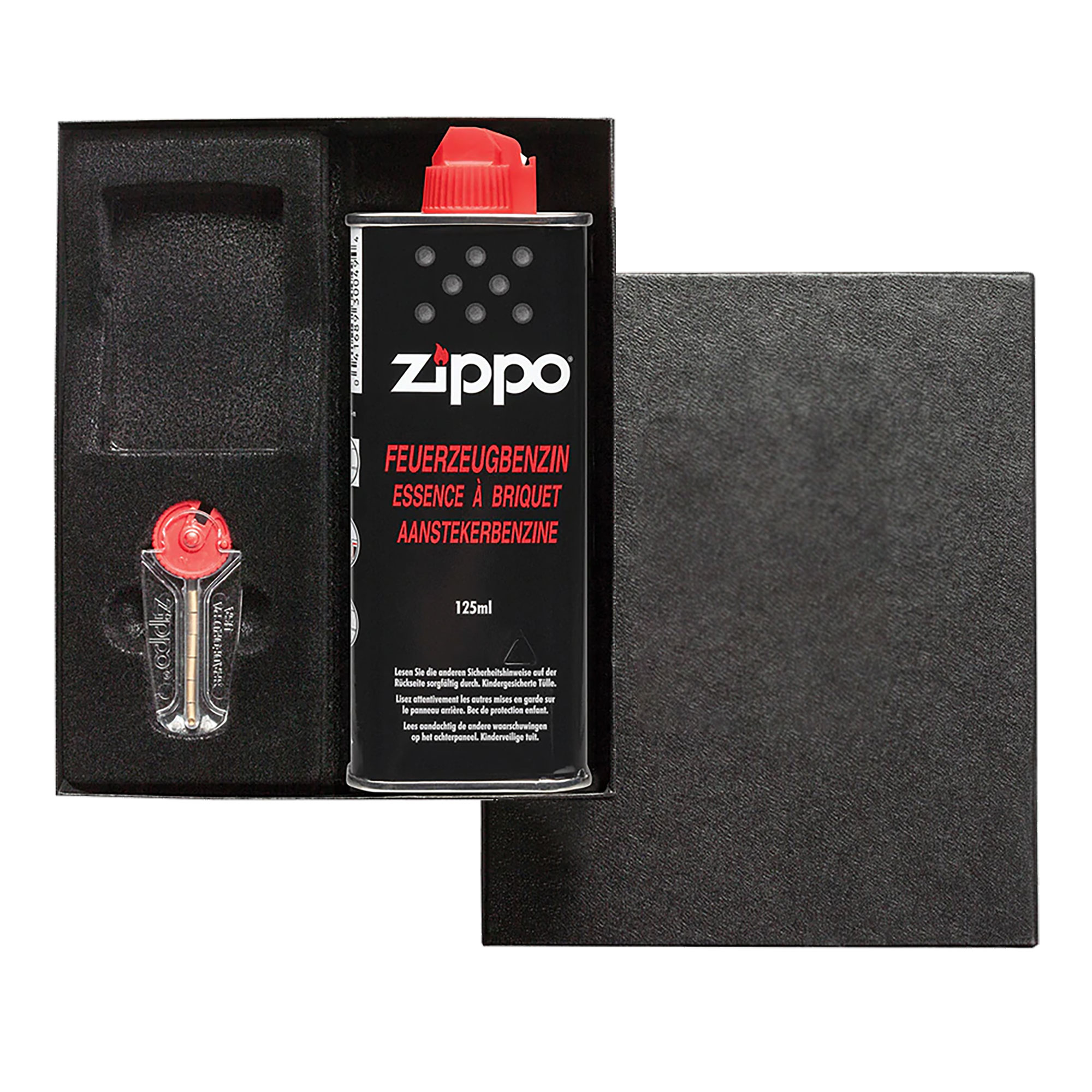 Zippo Box mit einer Flasche Benzin, Feuersteinen und einem Zippo, welcher mit einem Foto und Text graviert ist.
