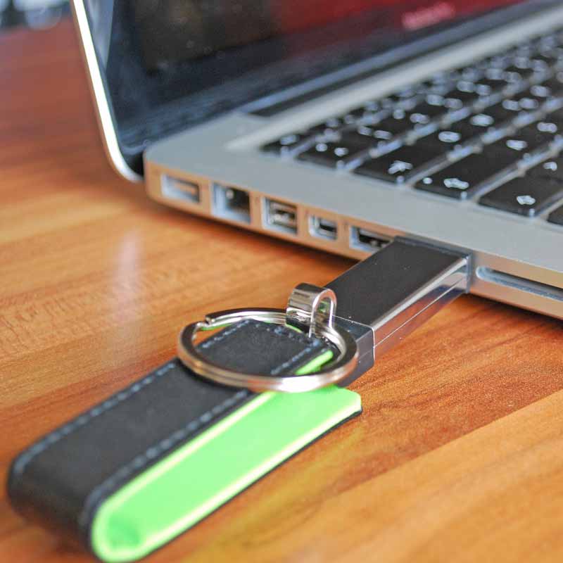 schwarzer USB Stick mit Lederemitat an MacBook